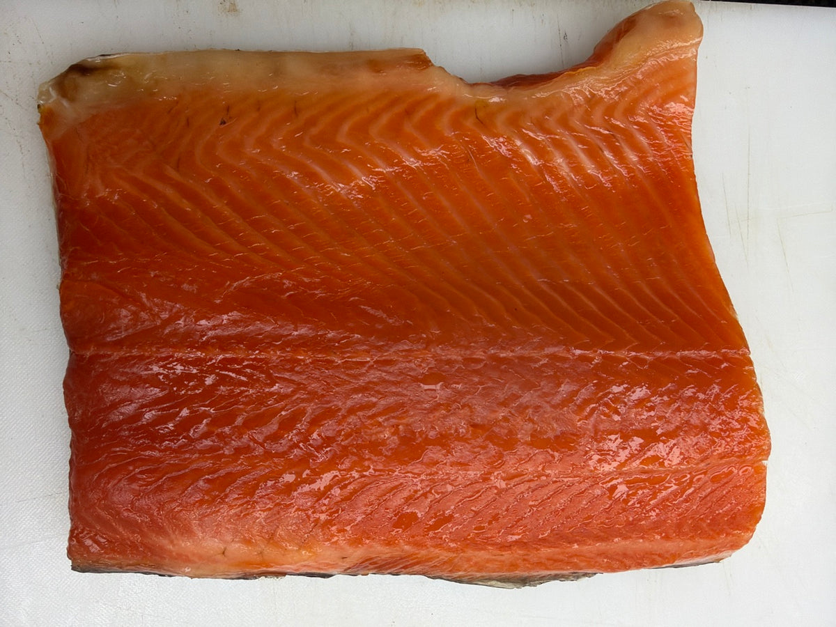 Cold smoked salmon fillet on a white cutting board