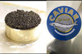 Kaluga black caviar in an open gold tin beside the blue Caviar Malossol tin lid