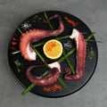 Cooked octopus legs plated with lemon